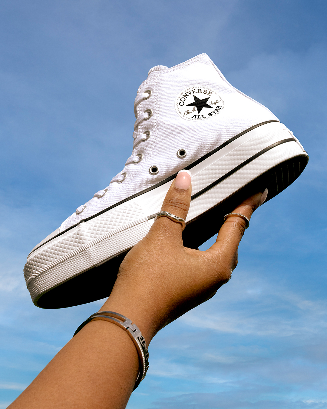 Converse All Star Hi in White Being Held in the Air