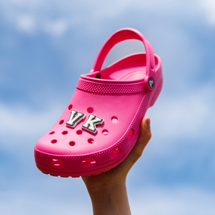 Pink Crocs Clogs being held up with Jibbitz