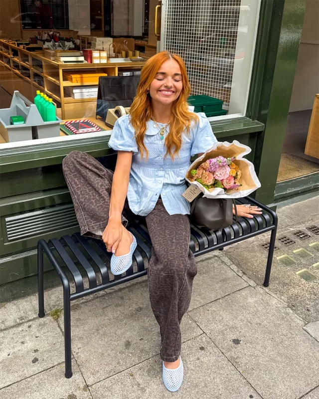 The shoe of the summer 🫧 @BryonyHeynes

Shop the JUJU JELLIES Billie Ballerina in a range of colourways, online and in-store now.

ID: A carousel of images. First image shows a person wearing a pair of pale blue JUJU JELLIES Billie Ballerina shoes with a brown and blue outfit whilst sitting next to a bouquet of flowers on a black bench in front of a stationery store. Second image shows a person wearing a pair of pale pink JUJU JELLIES Billie Ballerina shoes with a white t shirt and black handbag whilst sitting on a doorstep in front of a green door.